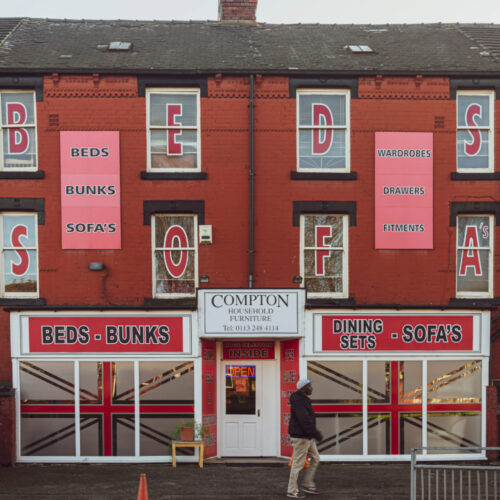 An image of the outside of Compton Household Furniture which is a furniture store held in a red brick building.
