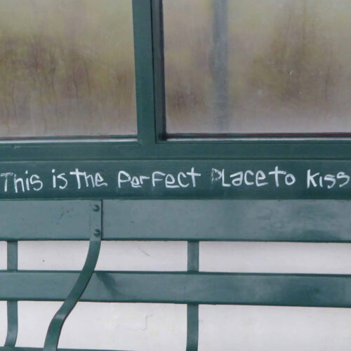 A close up image of the outside of a window frame. Someone has tagged the window frame with grafitti reading 