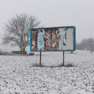 An empty billboard standing on a snowy field.
